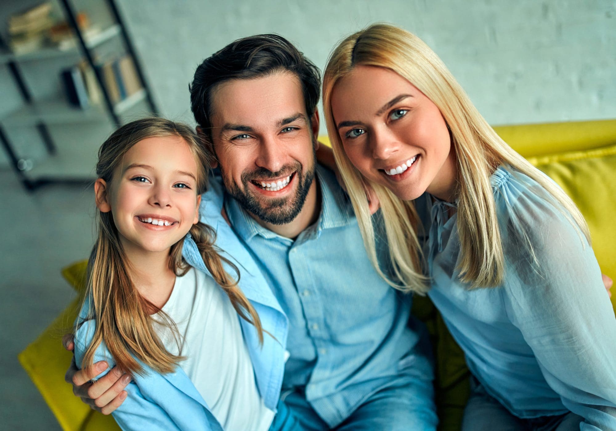 Smiling young parents and their child are very happy, they are at home